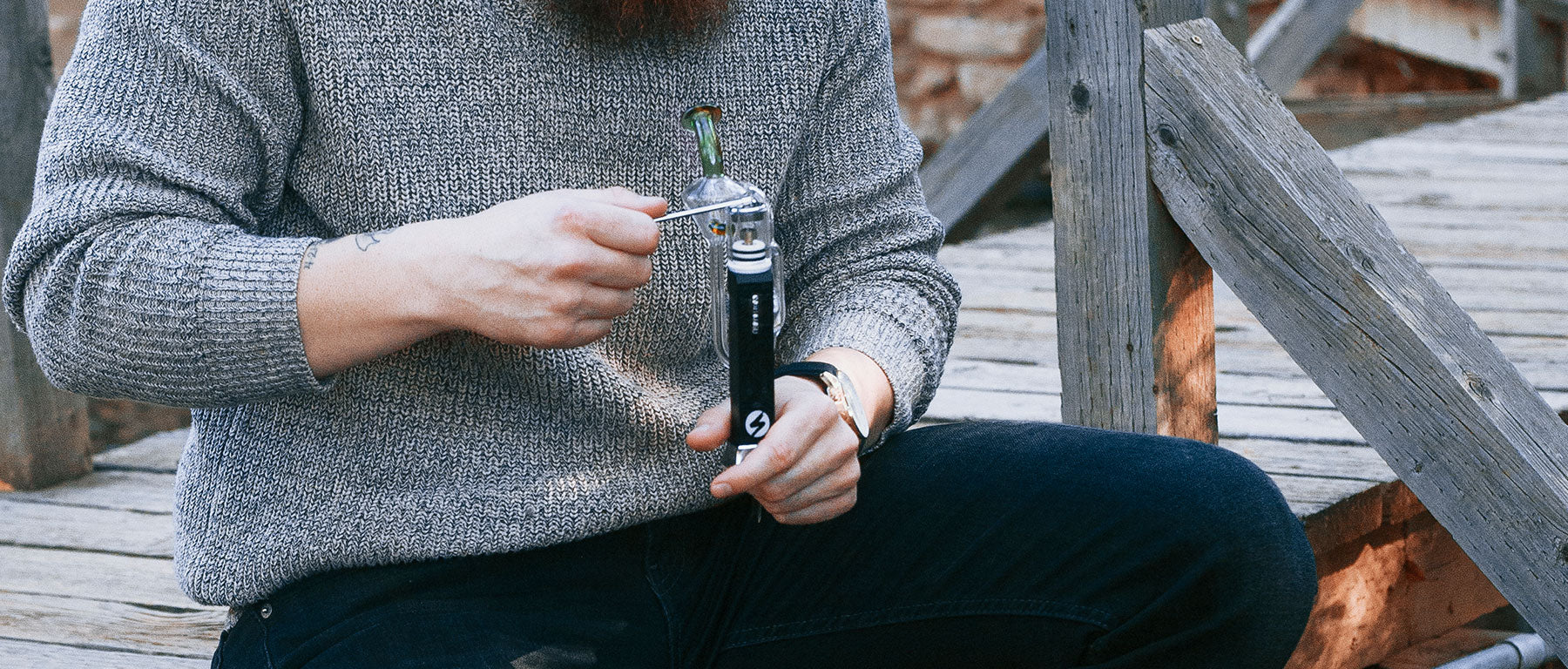Man holding Sutra DBR Concentrate Vaporizer outside near cabin