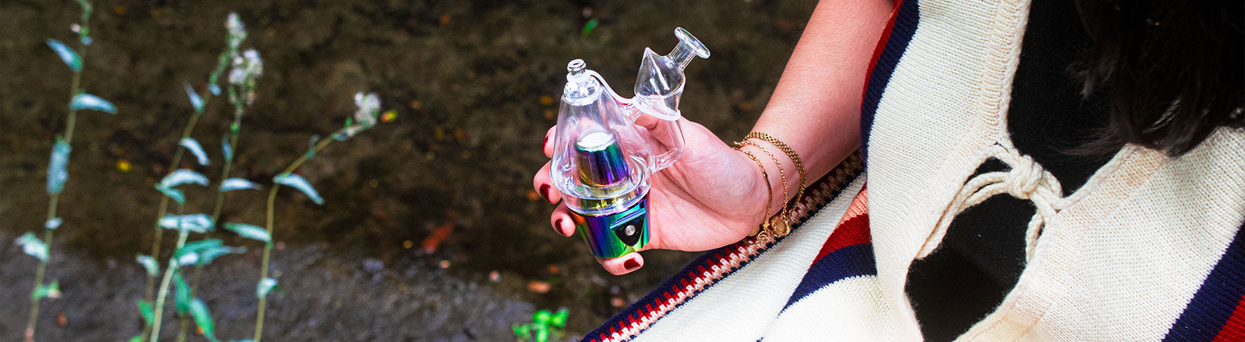 Man holding Sutra DBR Concentrate Vaporizer outside near cabin