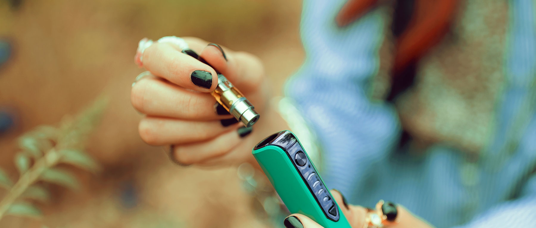 Woman holding Sutra Stik with Replacement Cartridge outside at park