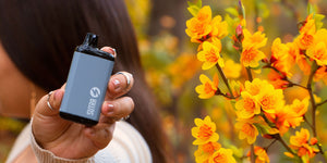 Woman holding sutra SILO pro by spring flowers 