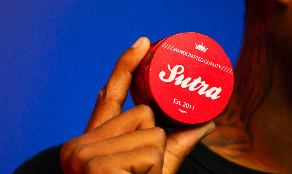 Man holding Sutra Grinder near neck inside studio