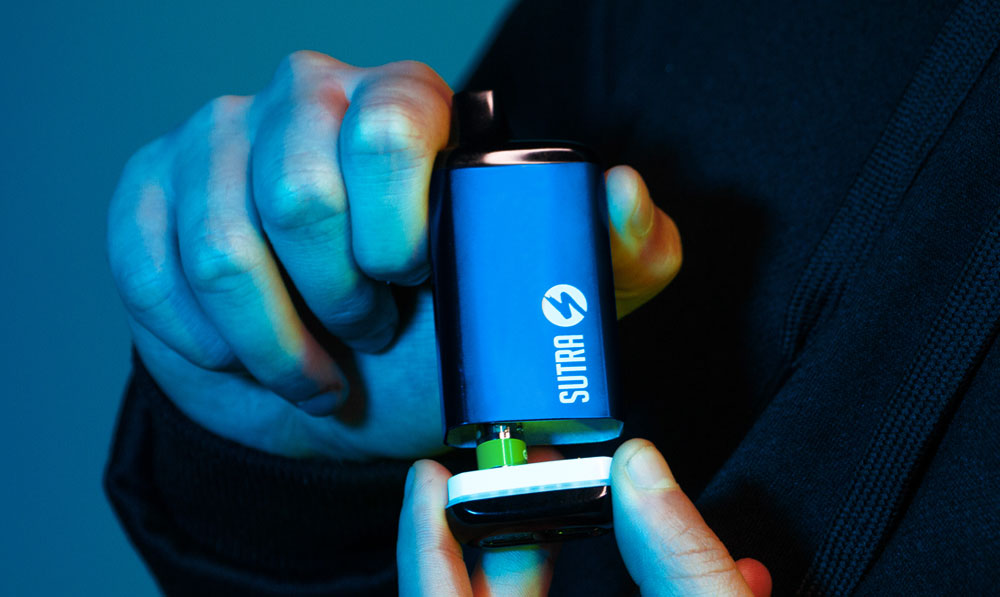 Man holding Sutra SILO Pro under blue studio lighting