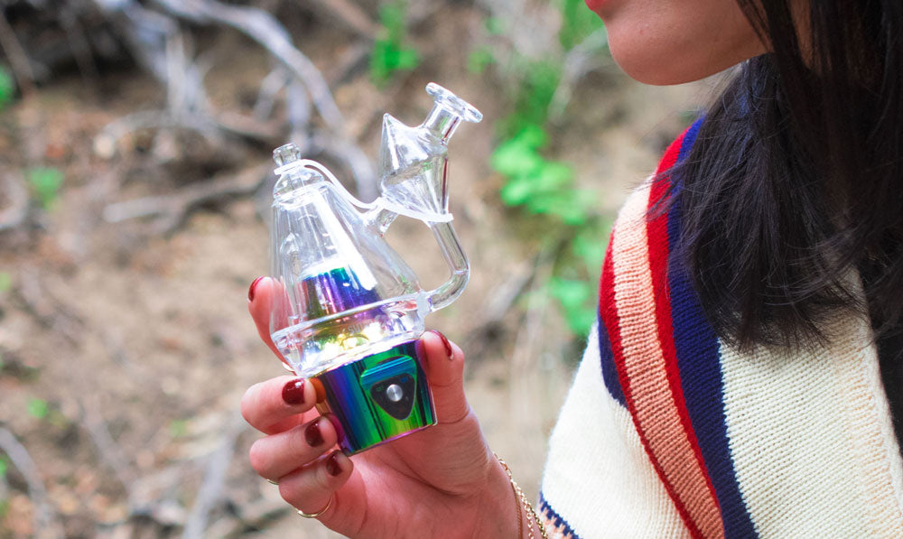 Woman holding Sutra DBR Pro in front of nature