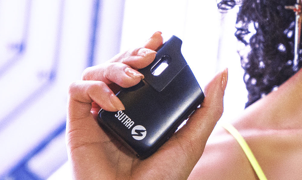 Woman holding Sutra Mini in front of arcade background