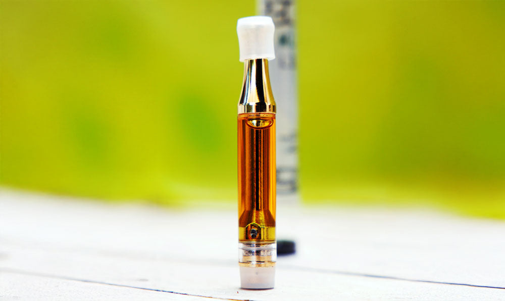 Single oil cartridge standing upright on wooden surface