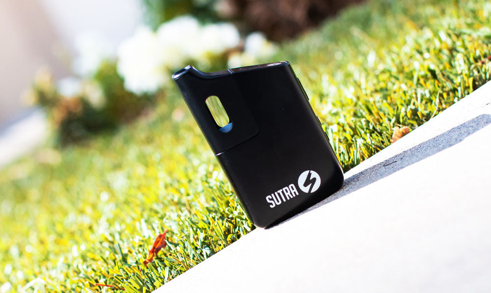 Sutra Mini vaporizer standing on a planter