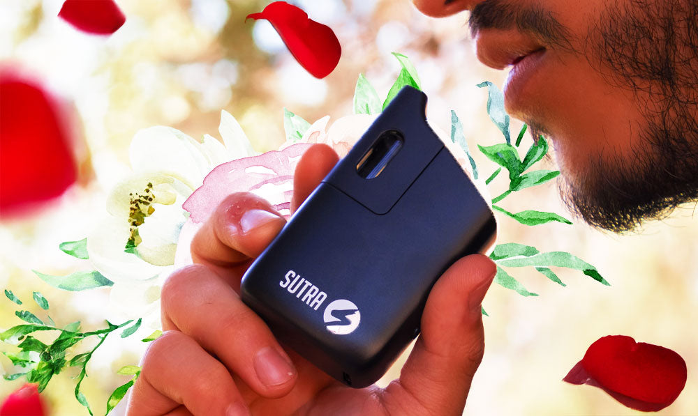 Person holding a Sutra Mini vaporizer among flower petals